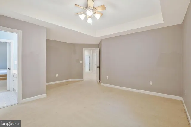 a view of an empty room with window and kitchen area