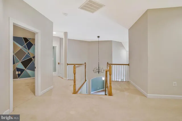 a view of a big room with windows and chandelier fan