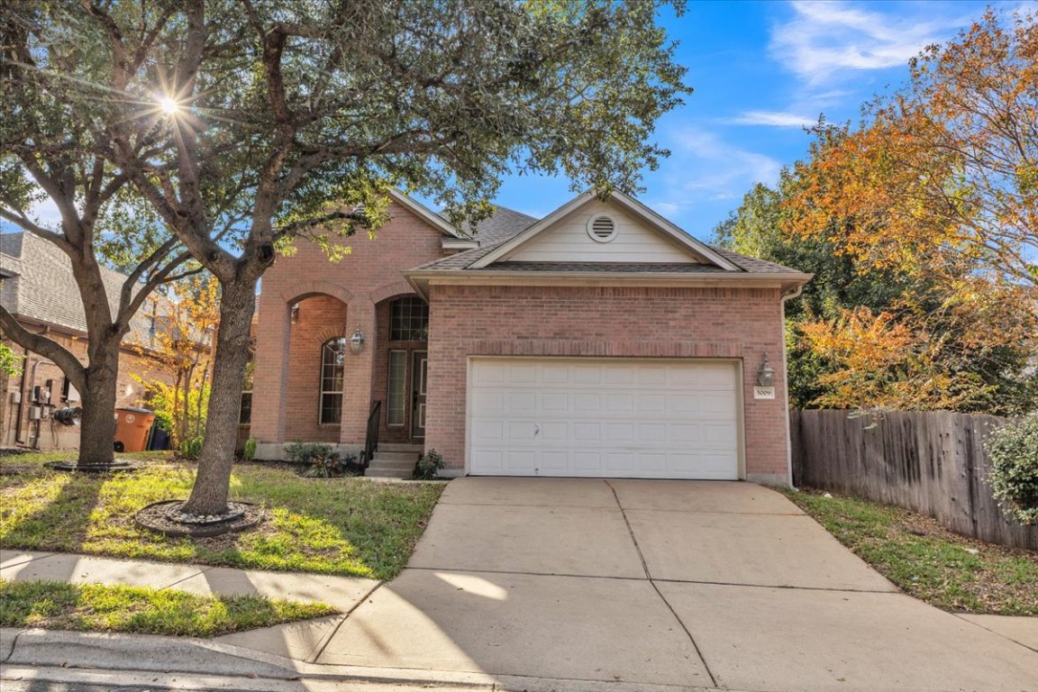 Traditional home featuring brick siding, concrete driveway, and an attached garage