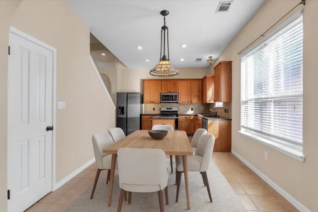 a view of an empty room with a window and a kitchen