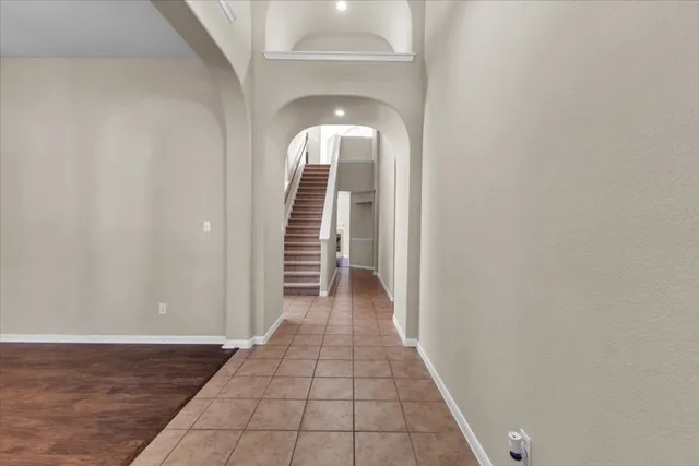 a view of a hallway with wooden floor and staircase
