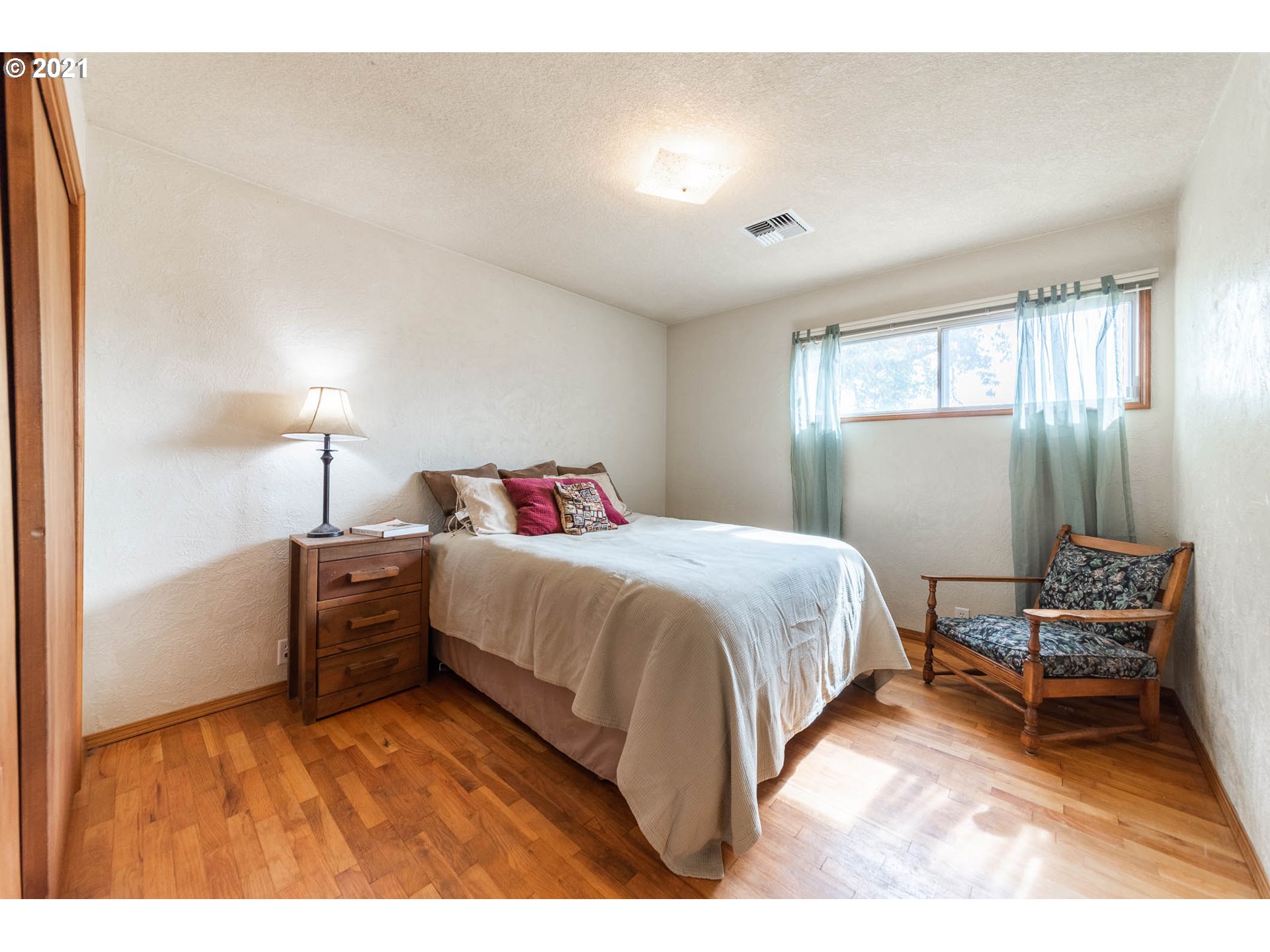 37931 M J Chase Road Springfield, OR 97478 - Photo 24 of 32 a spacious bedroom with a bed and a lamp