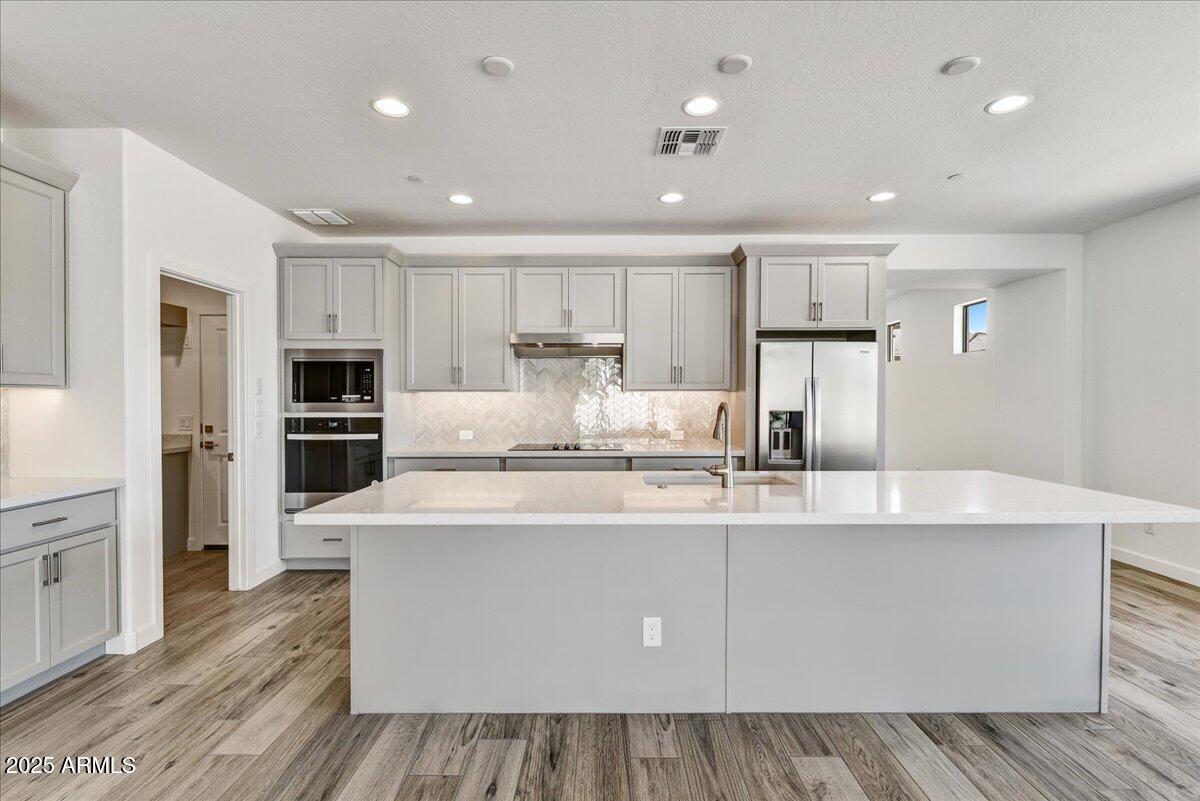 18230 East Coronado Cave Court Rio Verde, AZ 85263 - Photo 5 of 49 a large kitchen with stainless steel appliances a large counter top a stove and a refrigerator