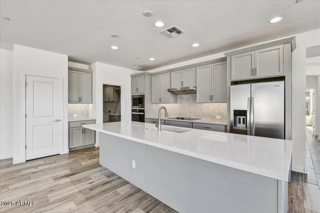 a large kitchen with kitchen island a sink stainless steel appliances and cabinets