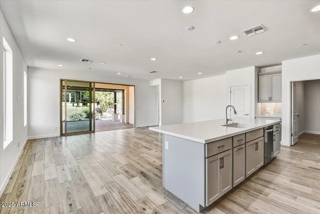 a kitchen with a sink and wooden floor
