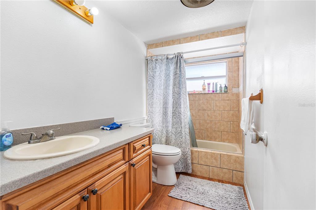 14450 Lancer Road Spring Hill, FL 34610 - Photo 24 of 46 a bathroom with a granite countertop sink a toilet a mirror and shower