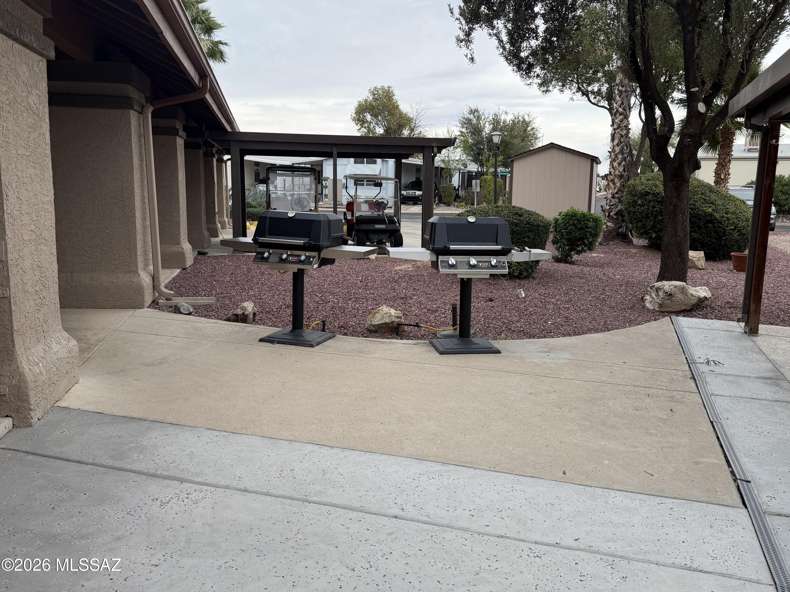 8401 South Kolb Road, Unit 168 Tucson, AZ 85756 - Photo 19 of 20 a view of a patio with table and chairs floor to ceiling window and a couple of houses