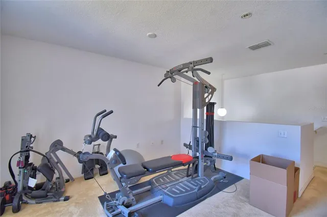 a spacious bedroom with a bed a dresser and a chandelier