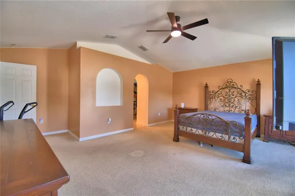 a bedroom with a large bed and a flat tv screen on dresser