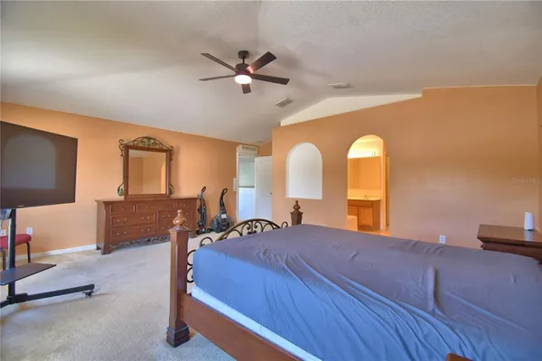 a bedroom with a bed a chandelier and a window