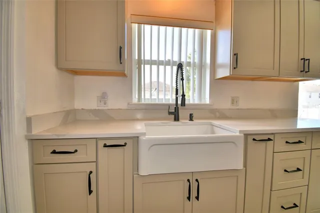 a view of a house with a yard and a large tree
