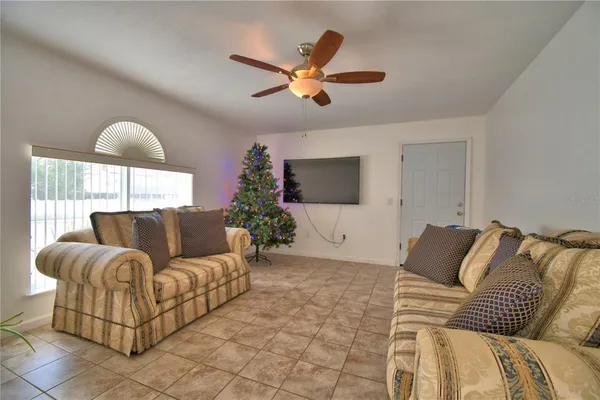 a view of a house with a yard and a large tree