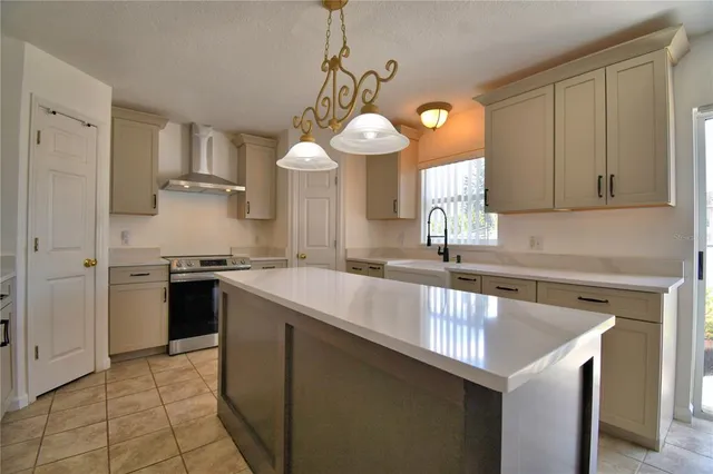 a kitchen with stainless steel appliances granite countertop a sink a refrigerator and a stove