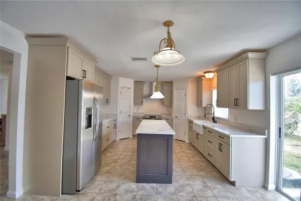 a kitchen with stainless steel appliances granite countertop a sink a refrigerator and a stove