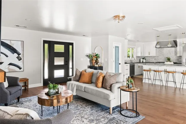 a living room with furniture and view of kitchen
