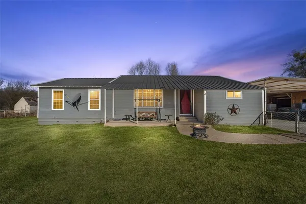 a view of a house with backyard and sitting area