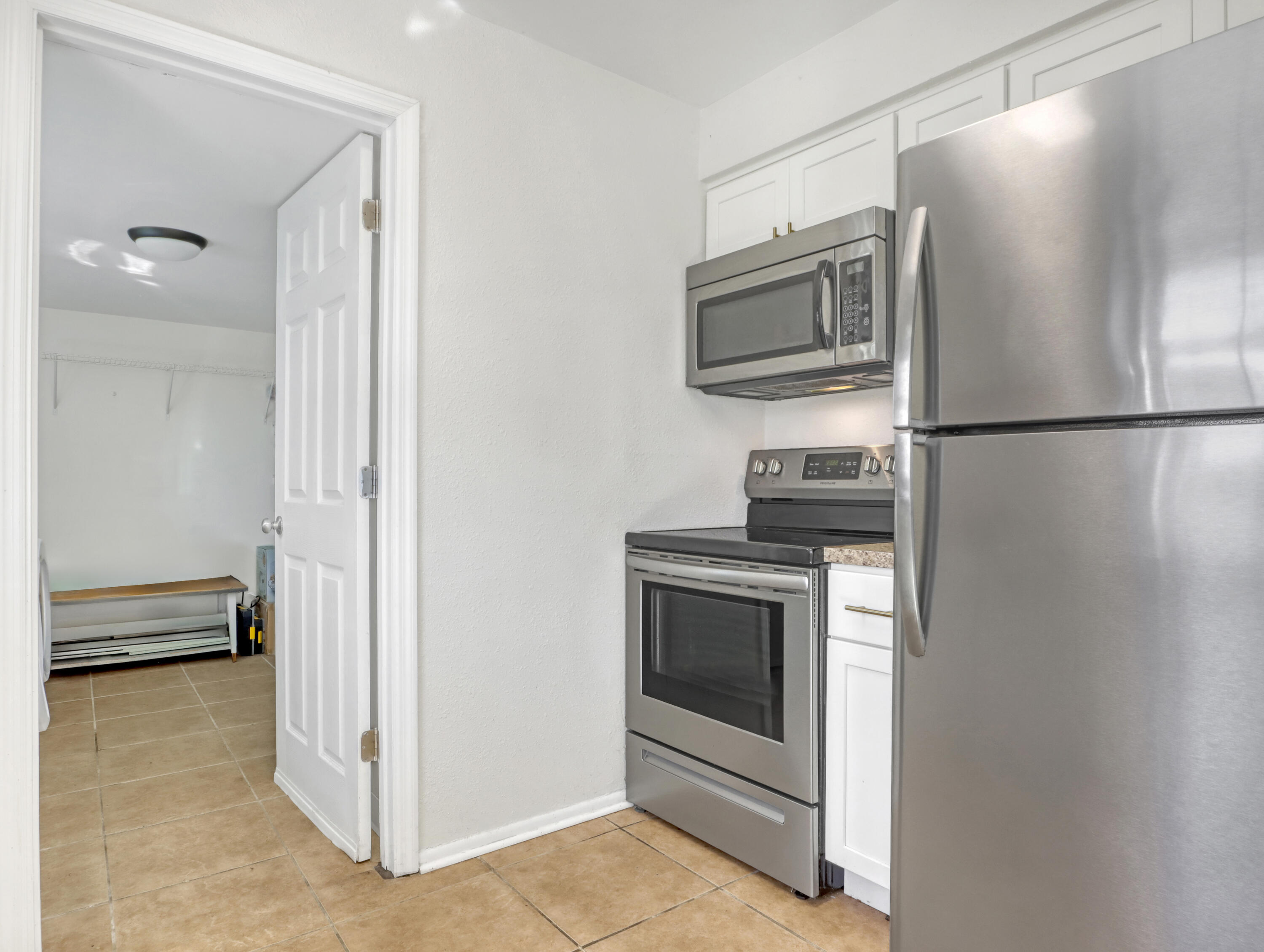 2711 Locksley Road Melbourne, FL 32935 - Photo 12 of 34 a kitchen with a refrigerator stove and microwave