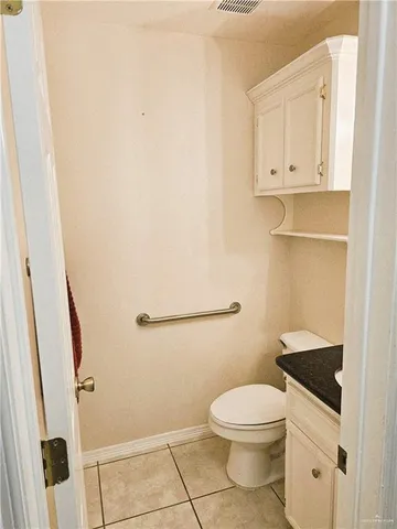 a bathroom with a granite countertop toilet and a sink