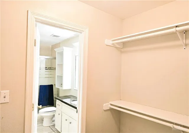 a bathroom with a granite countertop shower and a toilet