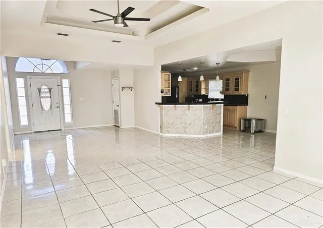 a view of a livingroom and a dining room and chandelier fan