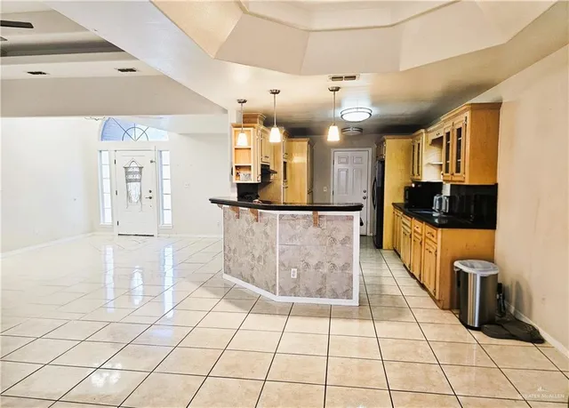 a large kitchen with granite countertop a stove a sink and a refrigerator