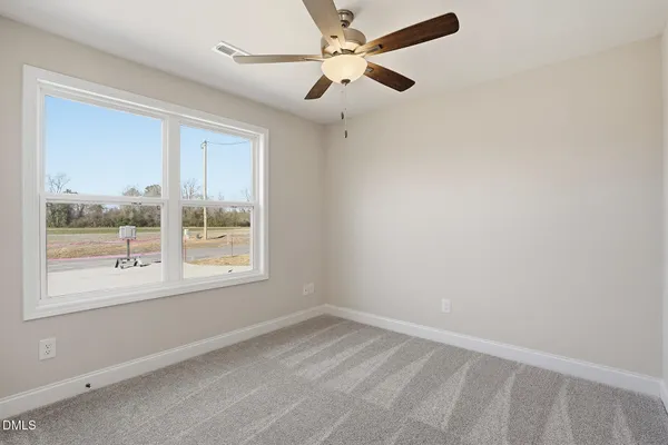an empty room with a window and a fan