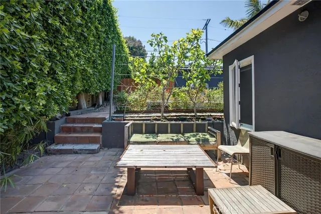 a view of a patio with table and chairs with wooden floor and plants