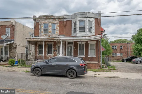 a car parked in front of a big house