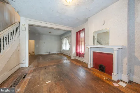 wooden floor with a fireplace in an empty room
