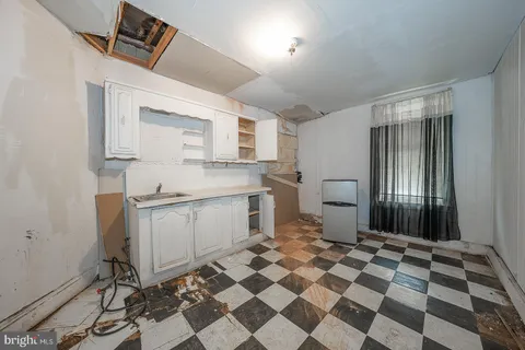 a kitchen with a checkered floor and white cabinets