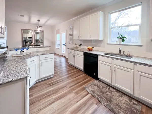 a large kitchen with a lot of counter space and wooden floor