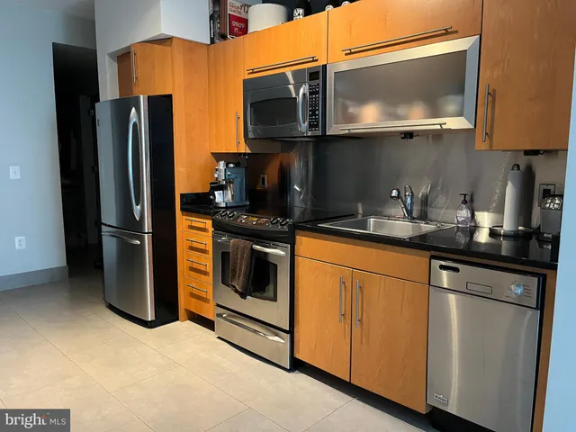 a kitchen with stainless steel appliances granite countertop a refrigerator stove and microwave