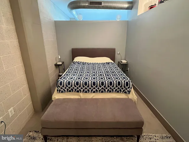 a bed sitting in a bedroom next to a window