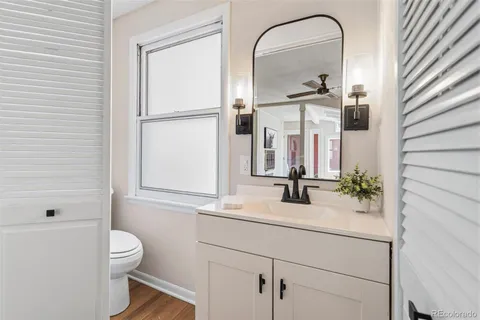 a bathroom with a granite countertop sink a toilet and a mirror