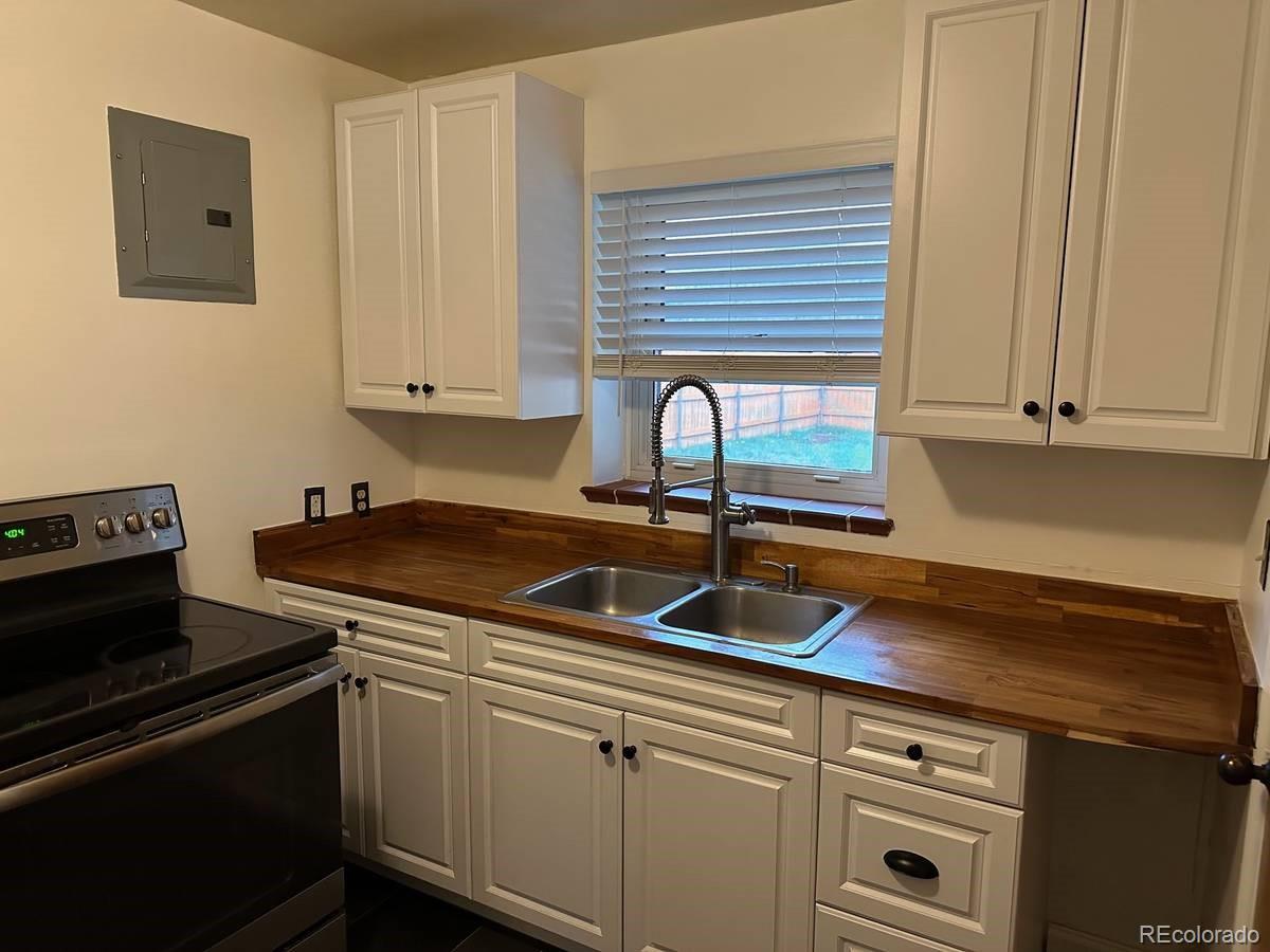 2050 Perry Street Denver, CO 80212 - Photo 5 of 15 a kitchen with granite countertop a sink stove and cabinets