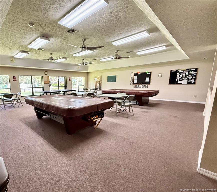 2574 Southwest Monarch Trail Stuart, FL 34997 - Photo 18 of 21 a living room with lots of furniture and a chandelier