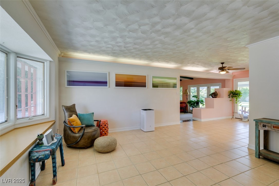 4087 Pleasant Road Las Vegas, NV 89108 - Photo 11 of 74 Living area with crown molding, light tile patterned flooring, and a ceiling fan