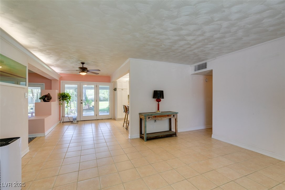 4087 Pleasant Road Las Vegas, NV 89108 - Photo 14 of 74 Unfurnished living room featuring light tile patterned flooring, ceiling fan, and ornamental molding