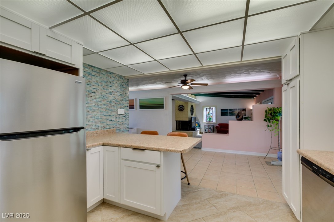 4087 Pleasant Road Las Vegas, NV 89108 - Photo 27 of 74 Kitchen with stainless steel appliances, tasteful backsplash, a ceiling fan, light countertops, and a kitchen breakfast bar