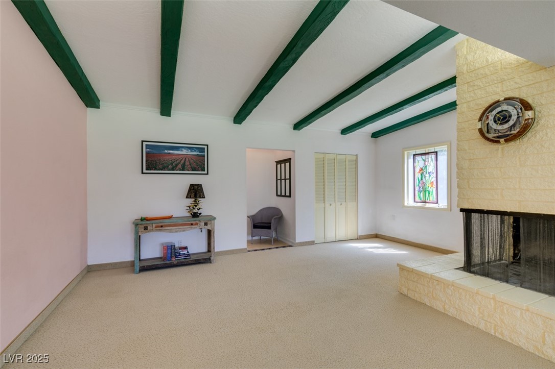 4087 Pleasant Road Las Vegas, NV 89108 - Photo 30 of 74 Unfurnished living room with a multi sided fireplace, beam ceiling, and carpet floors