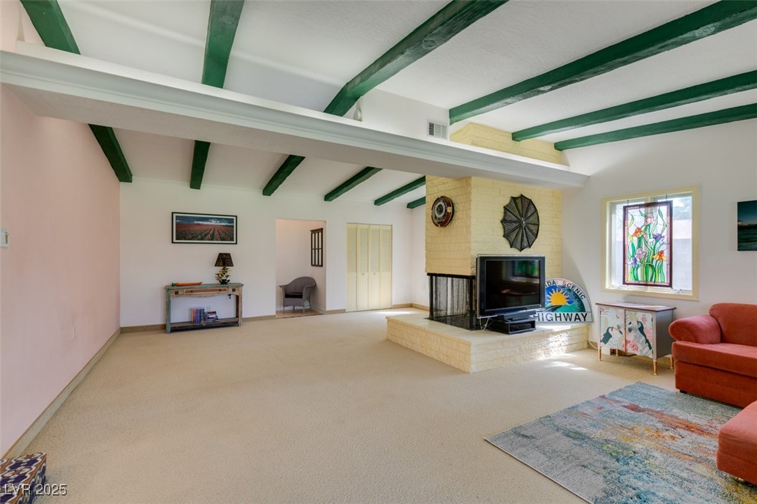 4087 Pleasant Road Las Vegas, NV 89108 - Photo 34 of 74 Carpeted living room with beamed ceiling and a brick fireplace