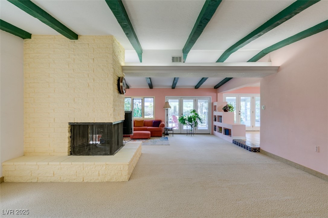 4087 Pleasant Road Las Vegas, NV 89108 - Photo 39 of 74 Carpeted living room with beamed ceiling, french doors, and a brick fireplace