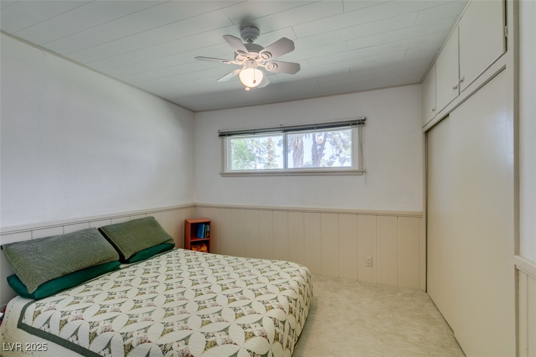 4087 Pleasant Road Las Vegas, NV 89108 - Photo 47 of 74 Carpeted bedroom featuring wainscoting and ceiling fan
