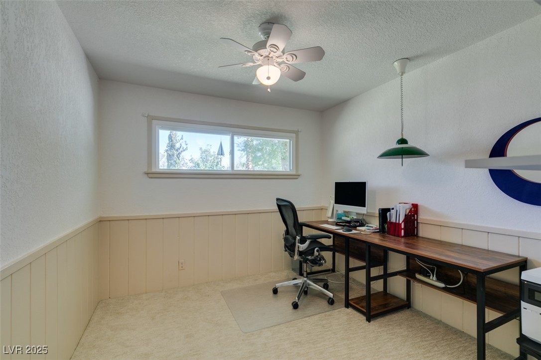 4087 Pleasant Road Las Vegas, NV 89108 - Photo 48 of 74 Carpeted home office featuring a wainscoted wall, a textured ceiling, a ceiling fan, and a textured wall