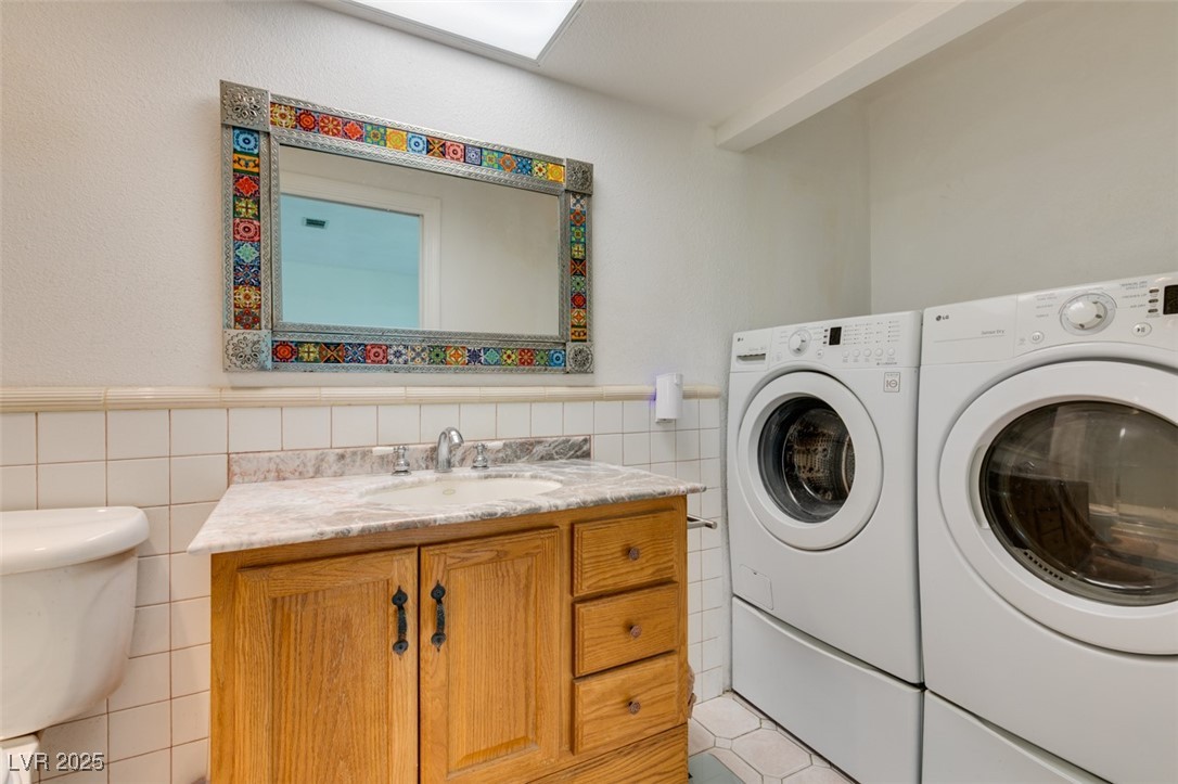 4087 Pleasant Road Las Vegas, NV 89108 - Photo 50 of 74 Laundry area featuring washing machine and clothes dryer, tile walls, and wainscoting