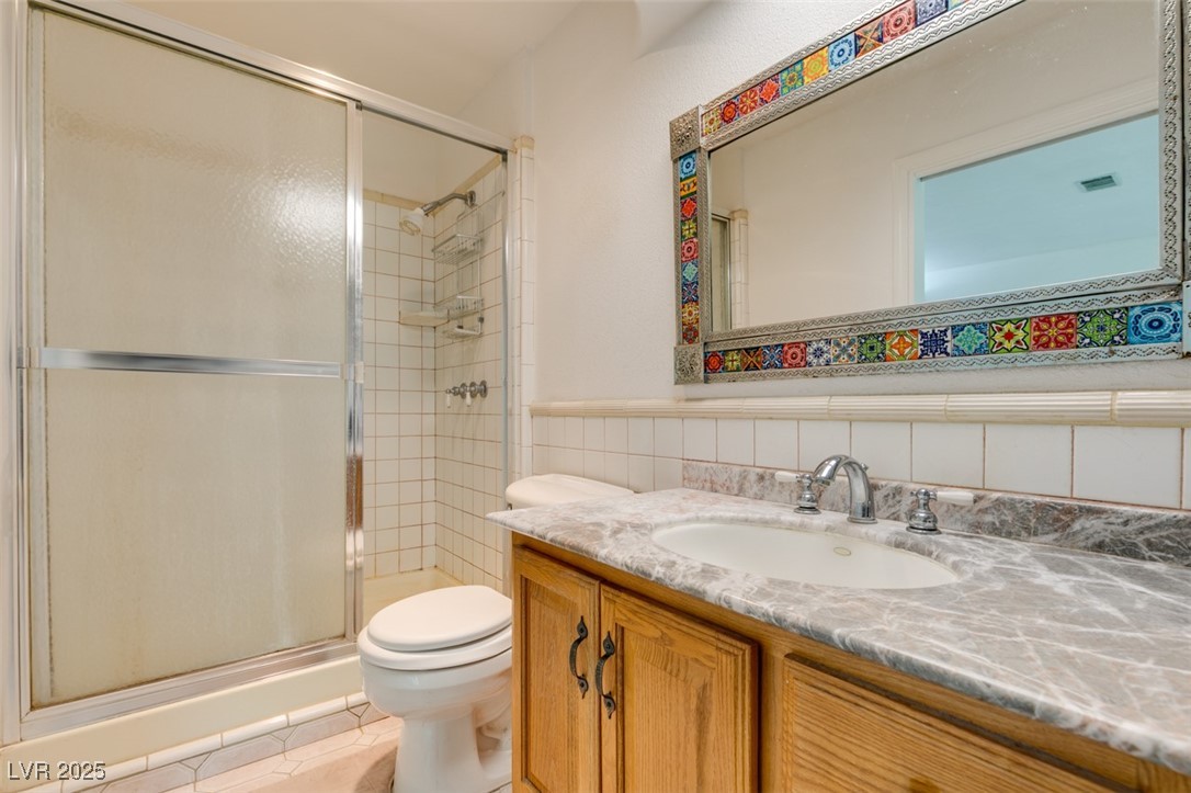 4087 Pleasant Road Las Vegas, NV 89108 - Photo 51 of 74 Full bath featuring a stall shower, vanity, tile walls, a wainscoted wall, and tile patterned flooring