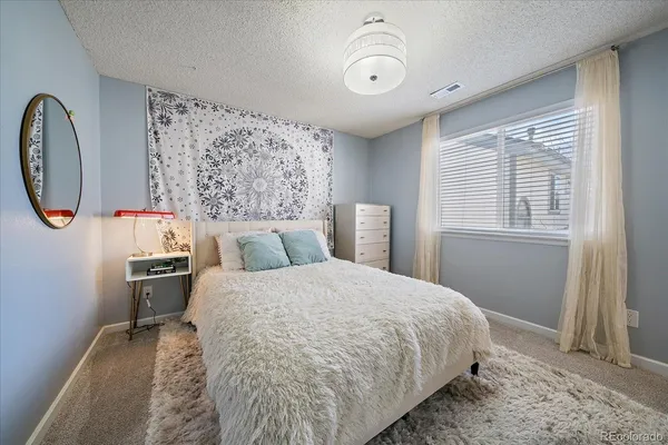 a bed sitting in a bedroom next to a window