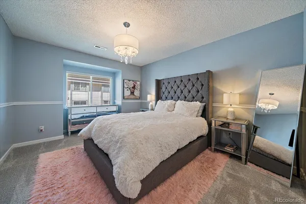 a bedroom with a large bed and a chandelier