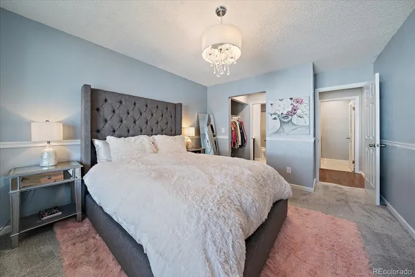 a spacious bedroom with a bed and a chandelier