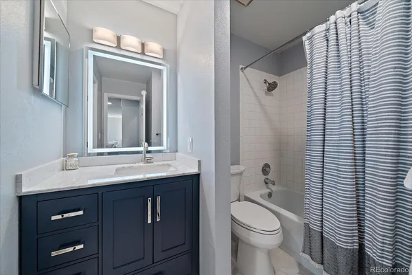a bathroom with a toilet a sink a mirror and shower curtain